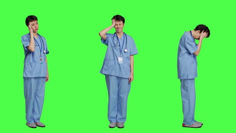 Unwohlsein-Einer-Krankenschwester,-Die-Vor-Einem-Greenscreen-Hintergrund-An-Kopfschmerzen-Leidet